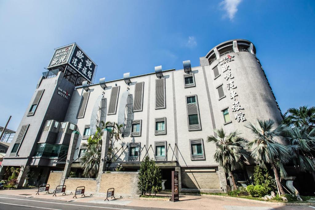 永康區的住宿－歐悅連鎖精品汽車旅館永康館，一座建筑的顶部有一个钟楼