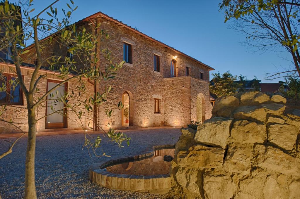 a stone building with a tree in front of it at Antica Quercia Villa & Spa in Chianciano Terme