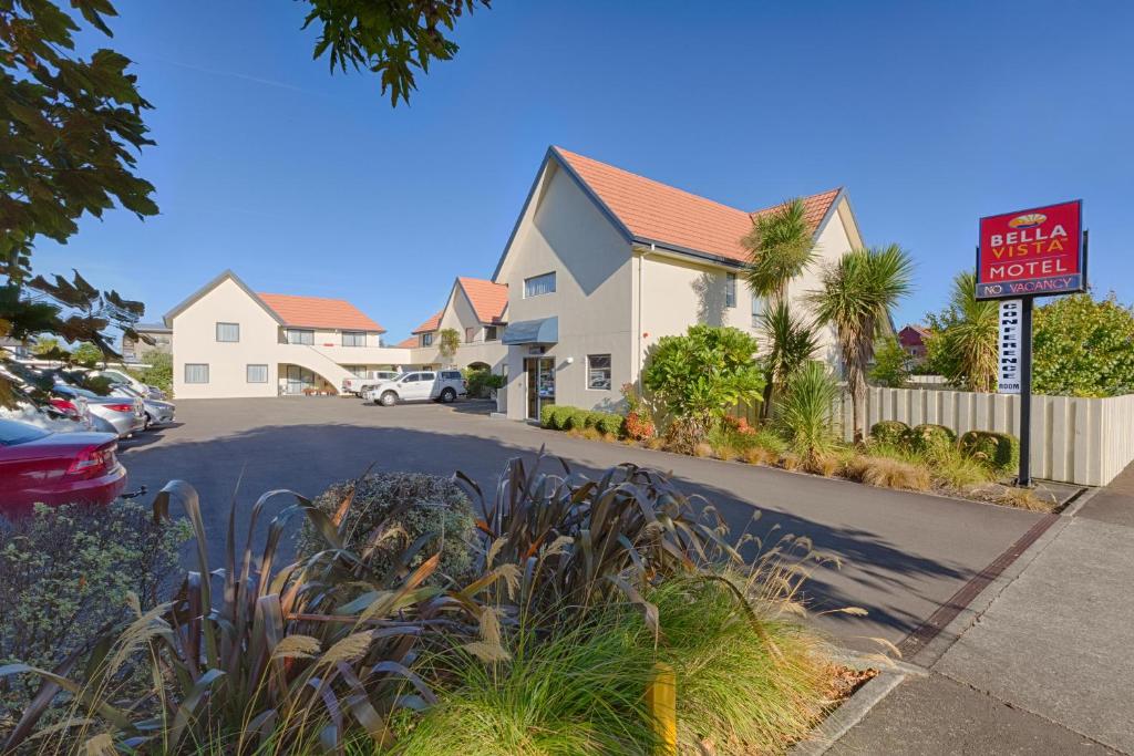 a house with a sign on the side of a street at Bella Vista Motel Palmerston North in Palmerston North