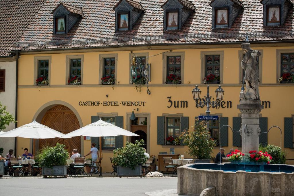 ein Gebäude mit einer Statue davor in der Unterkunft Gasthof zum Weißen Lamm in Sommerach