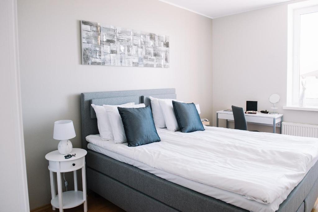 1 dormitorio con 1 cama grande con almohadas azules en Seaport Apartment, en Tallin