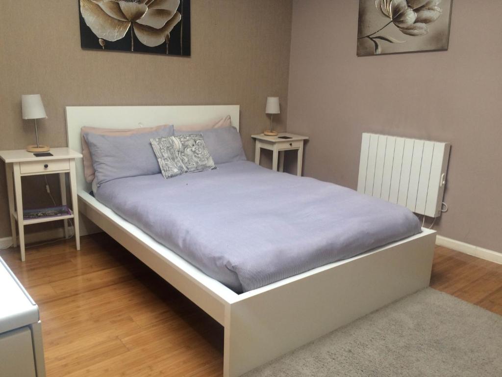 a bed in a bedroom with two night stands at Studio Apartments Camden Town in London