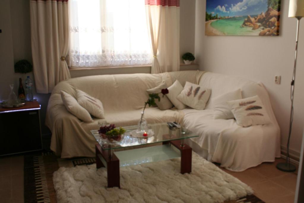 a living room with a white couch and a table at Apartament Centrum 3 pokojowy in Olsztyn