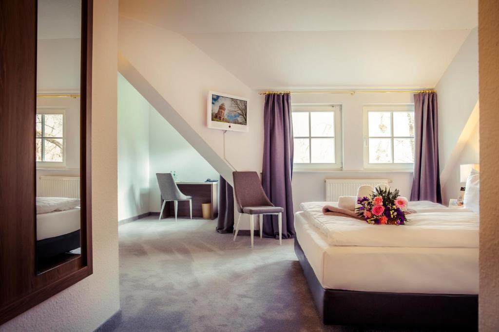 una habitación de hotel con una cama con flores. en Hotel am Rugard en Bergen auf Rügen