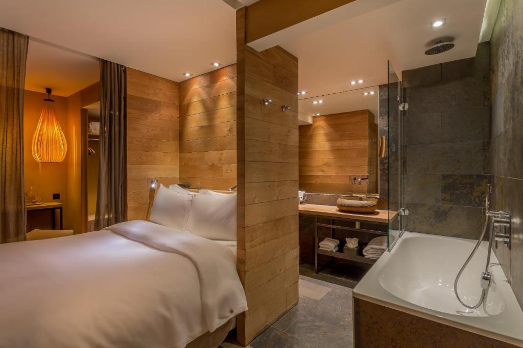 a hotel room with a bed and a bath tub at Hidden Hotel in Paris