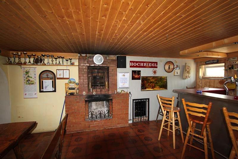 a bar in a restaurant with a fireplace in a room at Gästepension Sport 71 in Strasshof an der Nordbahn