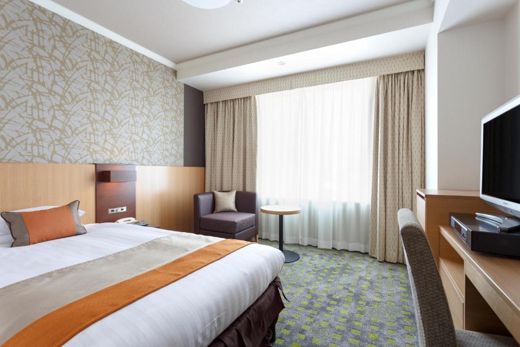 a hotel room with a bed and a flat screen tv at Shibuya Excel Hotel Tokyu in Tokyo