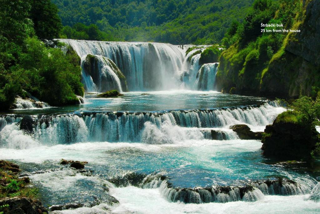 a waterfall in the middle of a river at House Greda in Bihać