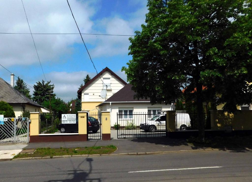 ハイドゥソボスローにあるAndi-házの通りの前に柵を持つ白い家