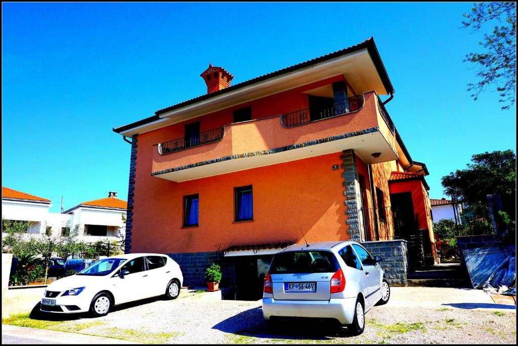 two cars parked in front of a house at Orlando's Apartments OJ in Izola