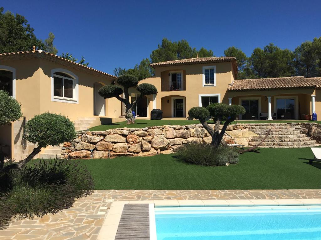 uma casa com piscina em frente a um quintal em Villa Sanata em Les Arcs sur Argens