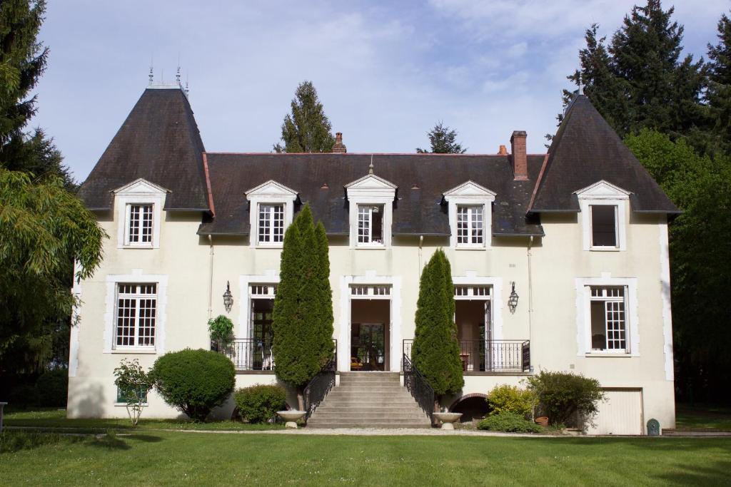 una grande casa bianca con una scala sul davanti di L'Hermitage a Saint-Martin-des-Champs