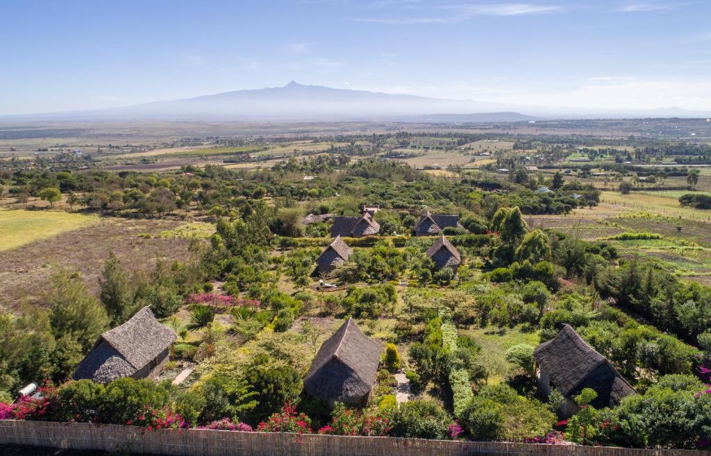 an aerial view of a farm with mountains in the background at Rhino Watch Safarilodge in Mweiga