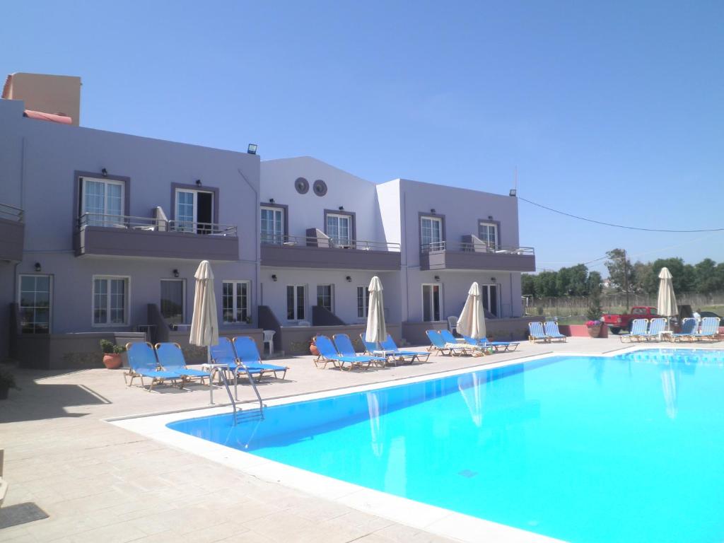 un hotel con piscina frente a un edificio en Haridimos Apartments en Tavronitis