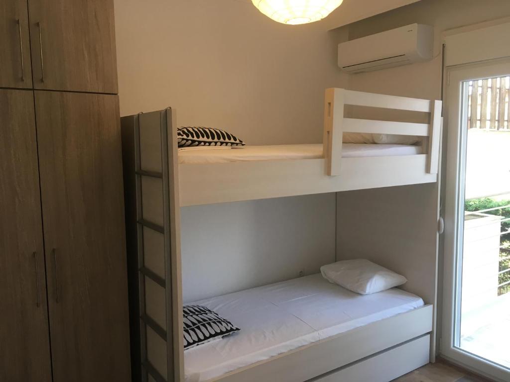 アギア・トリアダにあるTrinity Apartmentsの二段ベッドと窓が備わる小さな客室です。