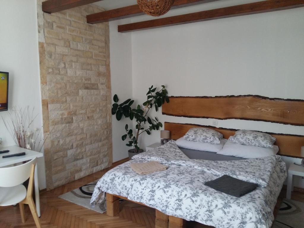 um quarto com uma cama e uma parede de tijolos em Apartmani Stonewood em Zagreb