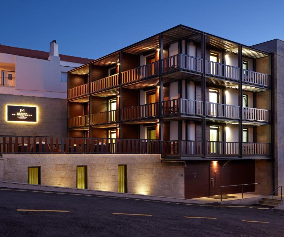 un edificio de apartamentos con balcones en un lateral en Abrigo da Montanha - Alojamento Familiar, en Sabugueiro