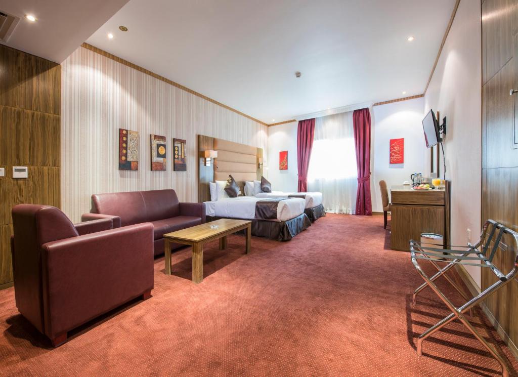 Habitación de hotel con cama y sofá en Royal Tulip Hotel LLC, en Dubái