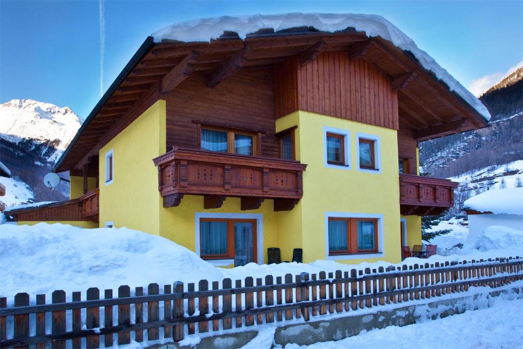 dom z drewnianym dachem w śniegu w obiekcie Haus Romana w Solden