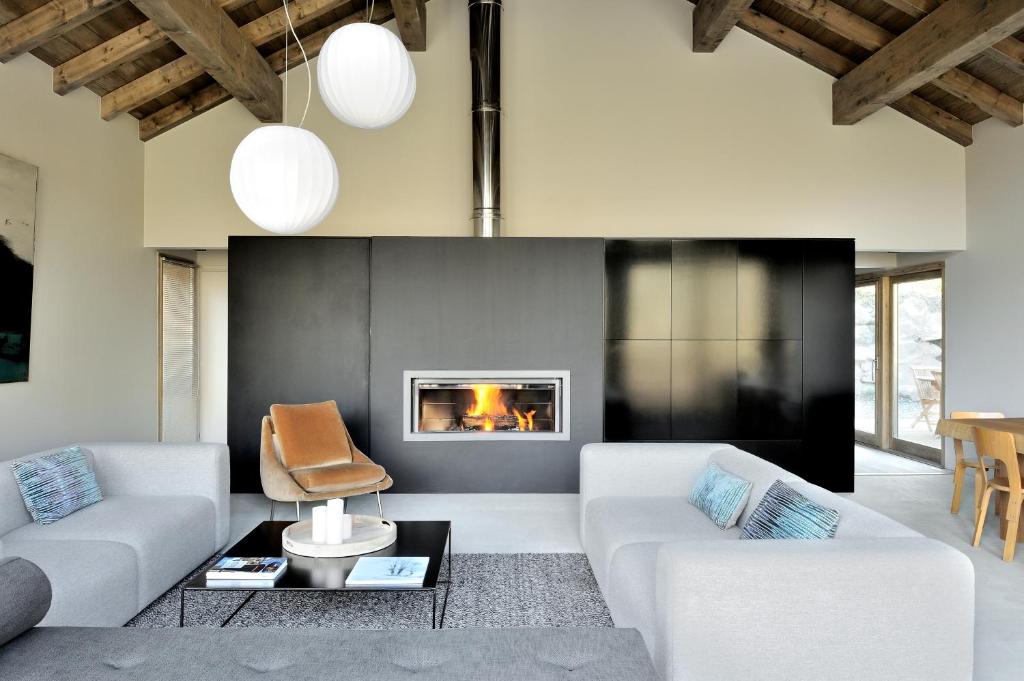 a living room with two white couches and a fireplace at Home by U - Chalet 2 in Saint-Martin-de-Belleville