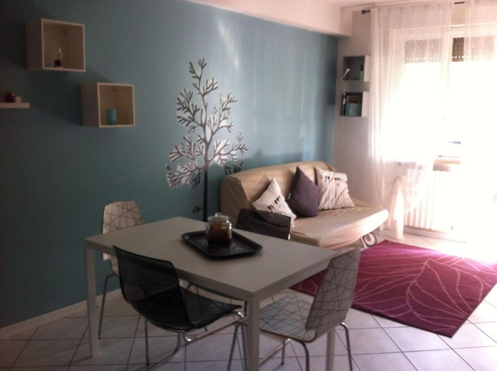 een woonkamer met een tafel en een bank bij Appartamento al Parco CIR03407AT00243 in Parma