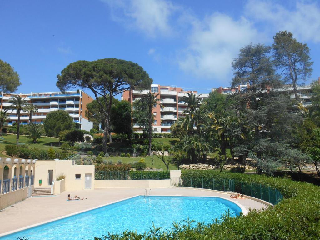 une piscine en face d'un bâtiment dans l'établissement Appartement Les Palmiers - Vacances Cote d'Azur, à Cannes