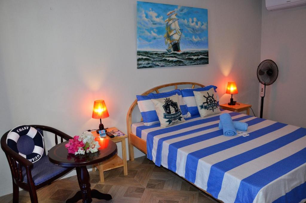 a bedroom with two beds and a table with lamps at Captain's Lodge and Bar in Panglao