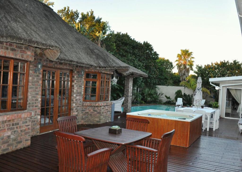 a patio with a hot tub and a table and chairs at Walmer Heights Guest House in Port Elizabeth