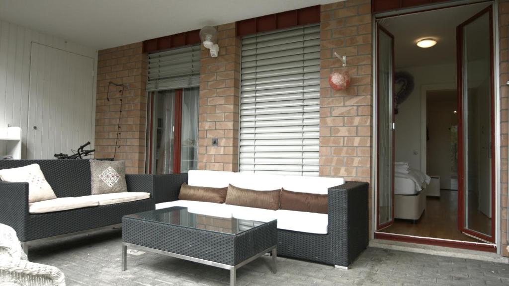 eine Terrasse mit einem Sofa und einem Couchtisch in der Unterkunft Home by Livingdowntown in Zug