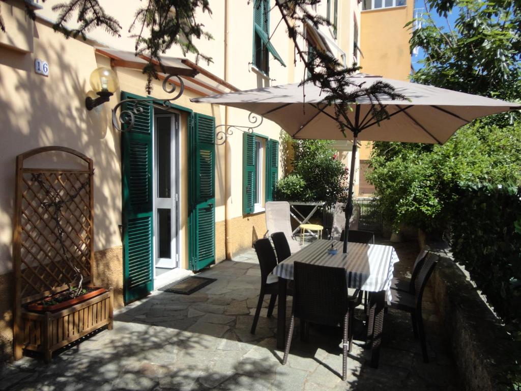 stół z parasolem obok budynku w obiekcie Varazze Apartment w mieście Varazze