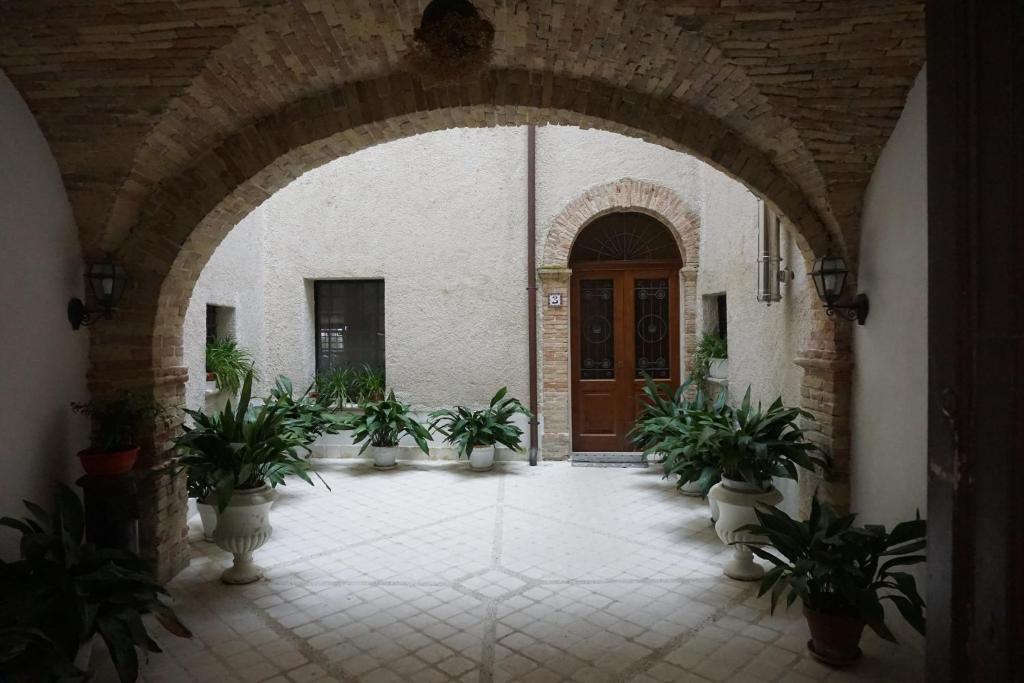 Zugang zu einem Gebäude mit Topfpflanzen im Flur in der Unterkunft Palazzo De Fabritiis in Rosciano