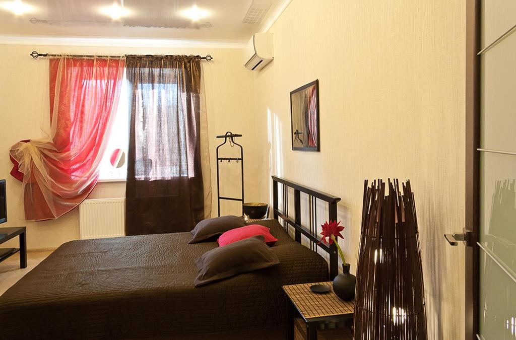 ヴォロネジにあるCozy and Comfortable Apartment in the Centreのベッドルーム1室(大きな黒いベッド1台、窓付)