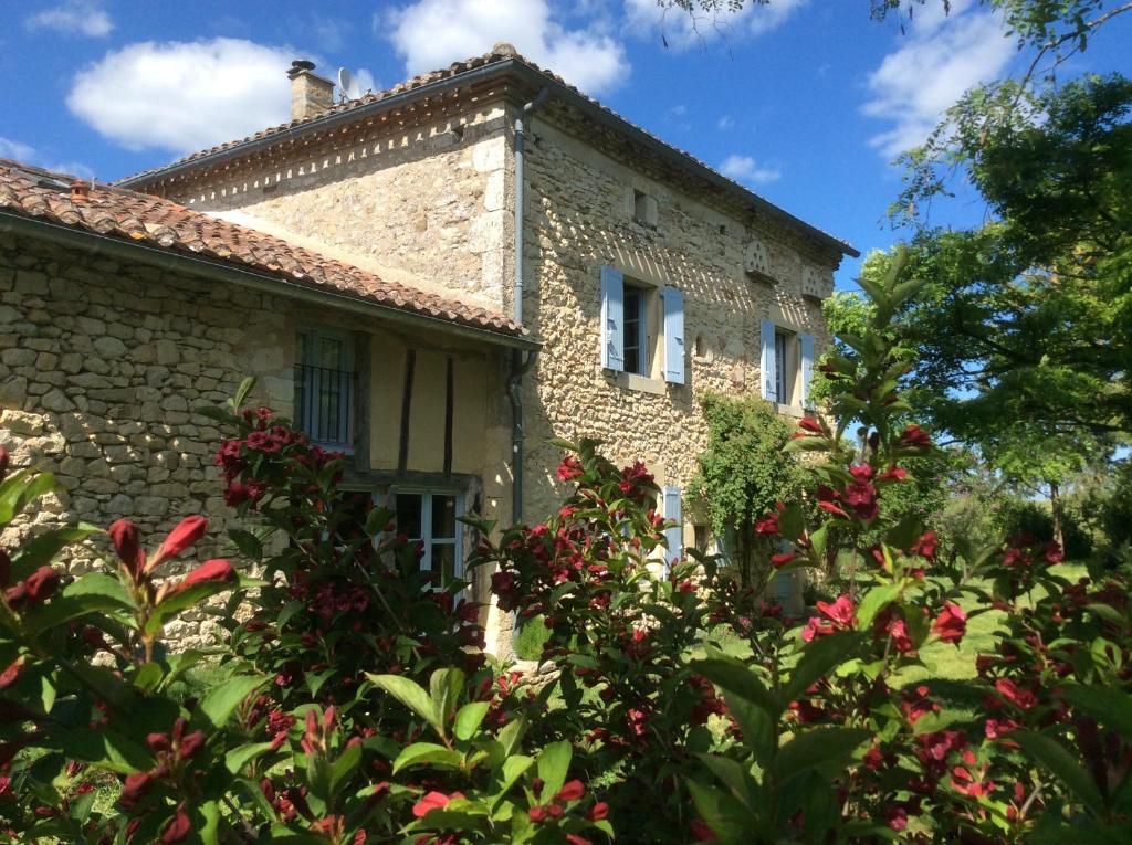 an old stone house with flowers in front of it at Le Clos Pastel in Virac