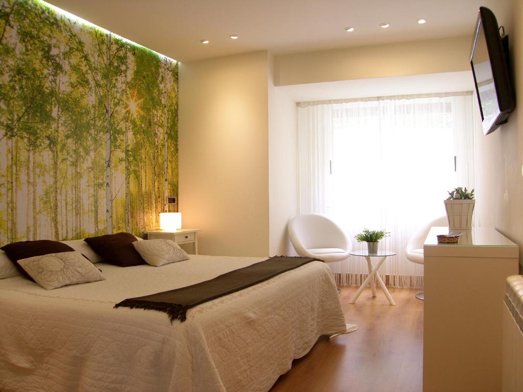 a bedroom with a large bed and a large window at Melida Ostatua in Ermua