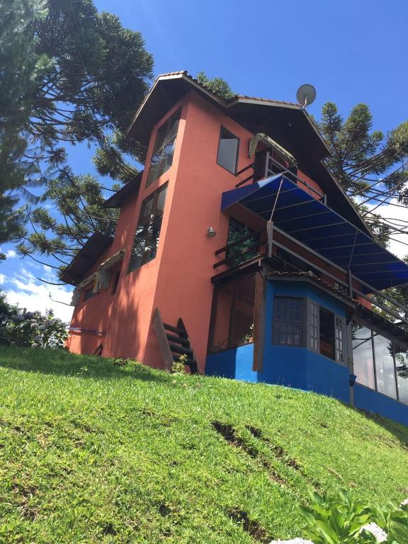 a house on top of a grassy hill at Refúgio dos Sonhos - Casa nas Montanhas - Monte Verde in Monte Verde