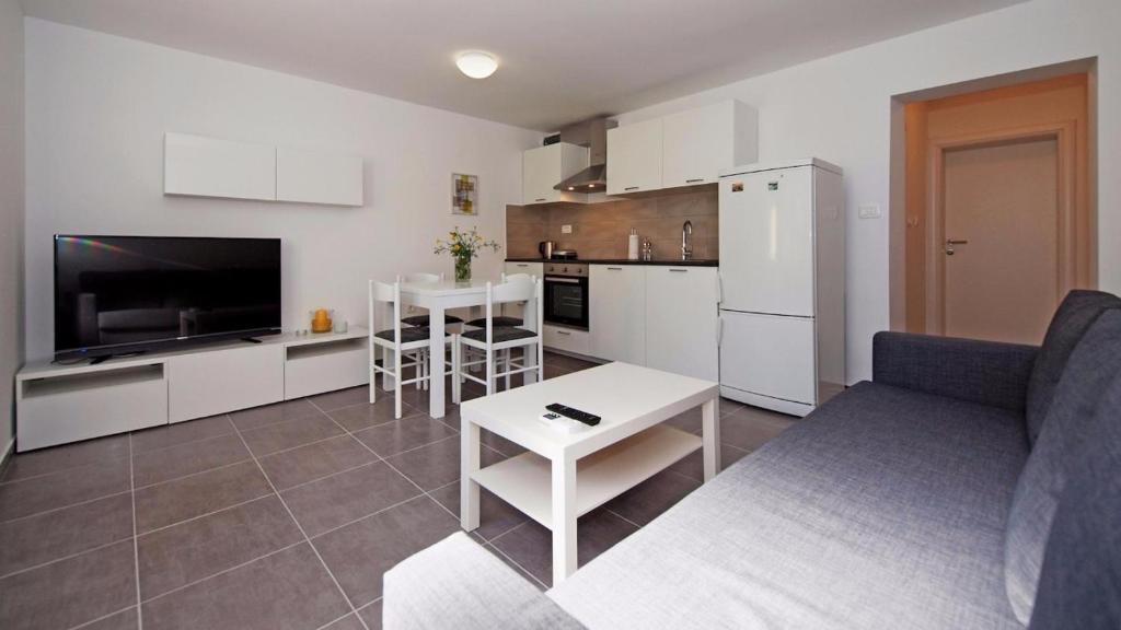 eine Küche und ein Wohnzimmer mit einem Sofa und einem Tisch in der Unterkunft Apartments Mare in Vodice