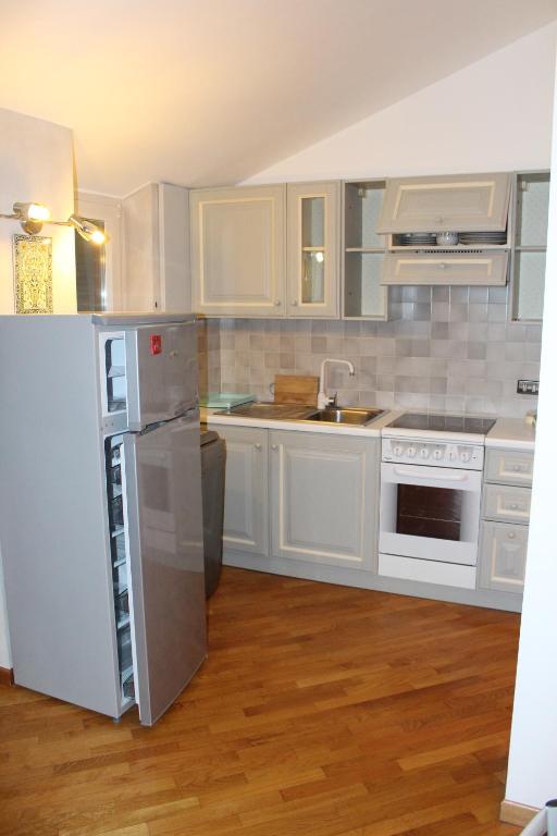 kuchnia z białymi szafkami i lodówką w obiekcie Casa Lumiere w Aoście