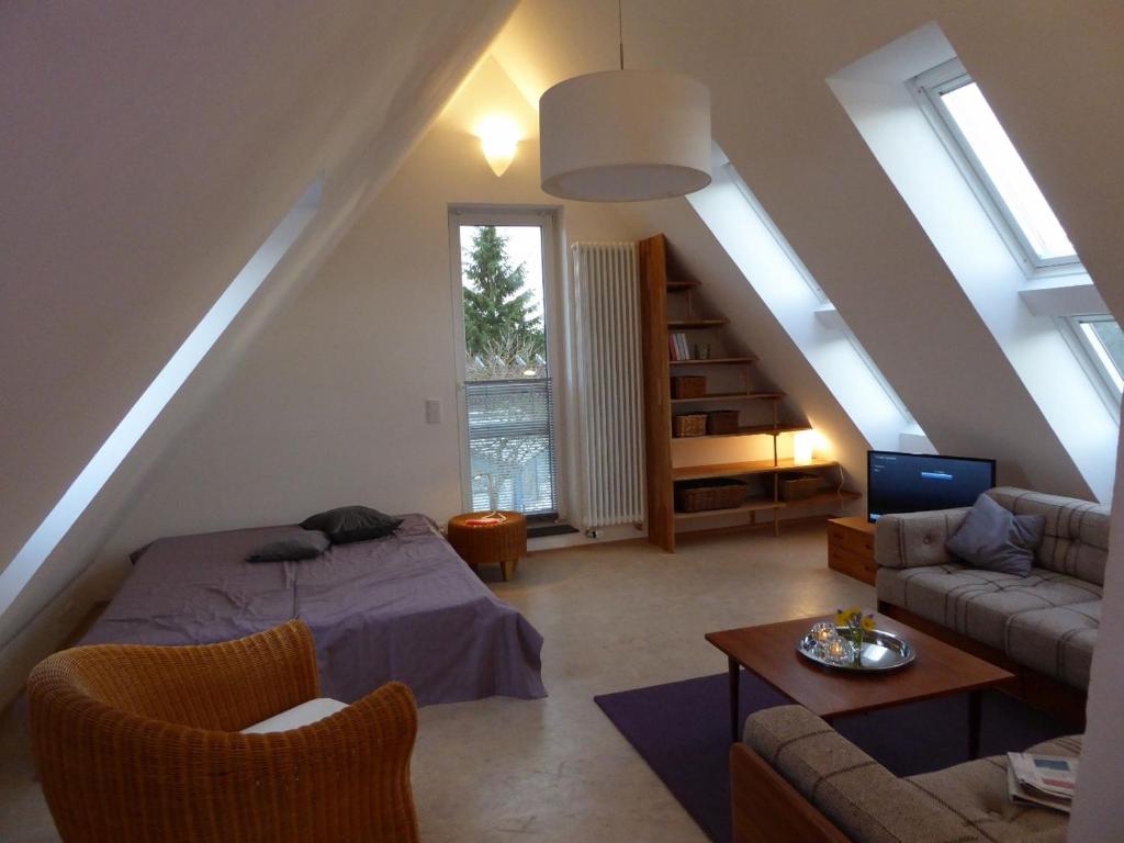 Cette chambre mansardée comprend un lit et un salon. dans l'établissement Ferienwohnung Max, à Cassel