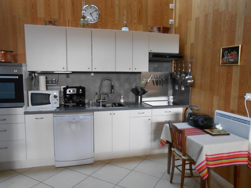 a kitchen with white cabinets and a sink at Gite du Cret in Hotonnes