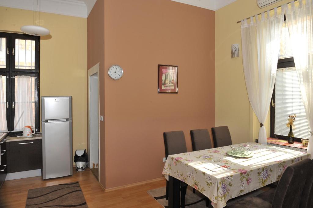 een keuken en eetkamer met een tafel en een koelkast bij Tesla Apartment in Sarajevo