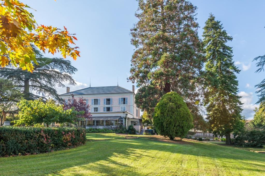 a large white house with trees and a lawn at Chateau de Breuil en Beaujolais in Salles-Arbuissonnas