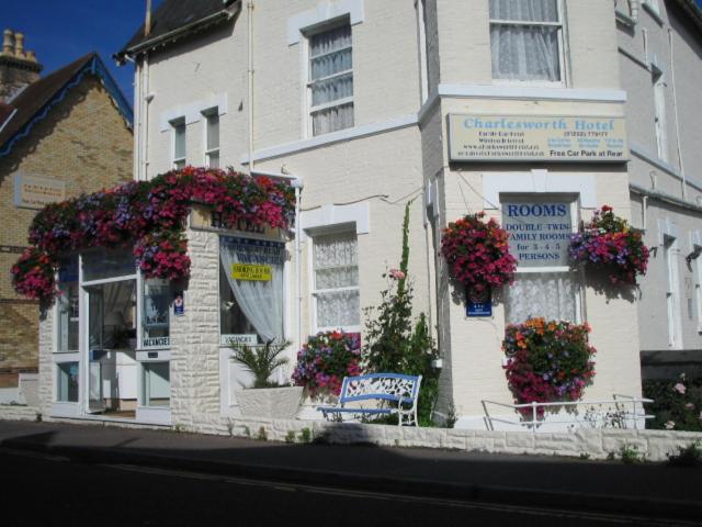 Un bâtiment blanc avec des fleurs devant lui dans l'établissement The Charlesworth, à Bournemouth