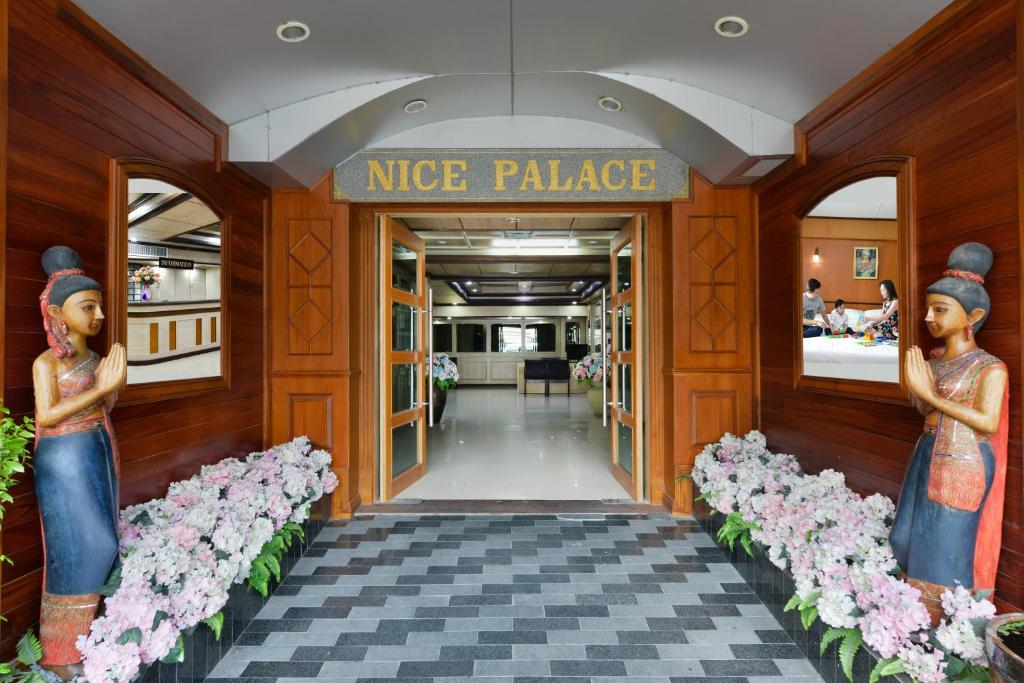 a nice palace lobby with two statues of women at Nice Palace Hotel in Bangkok