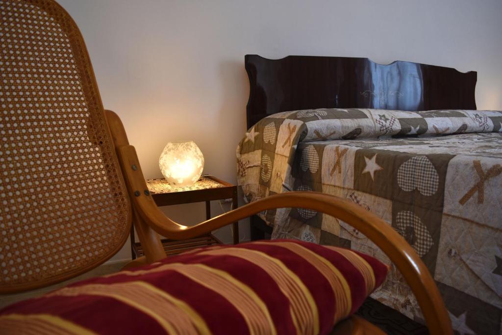 ブゼート・パリッツォーロにあるCasa Mazzaraのベッドルーム(椅子、ベッド、ランプ付)