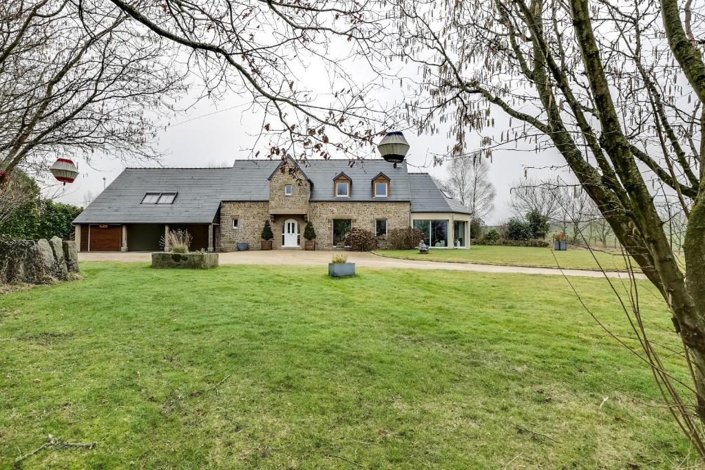 a large stone house with a large yard at Le bouddha du lac in Saint-Germain-de-Tallevende