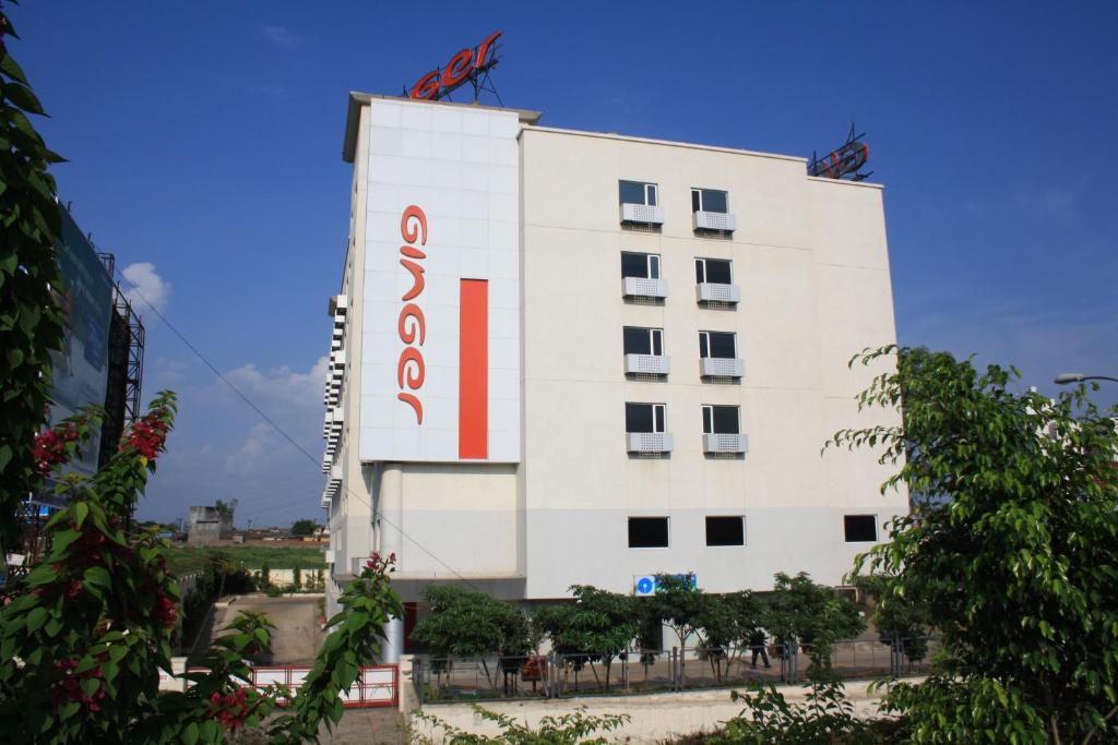 un edificio blanco con un letrero rojo. en Ginger Faridabad, en Faridabad