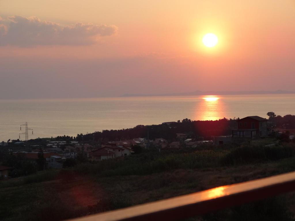 a sunset over the ocean with the sun in the sky at Canapè Apartments in Patti