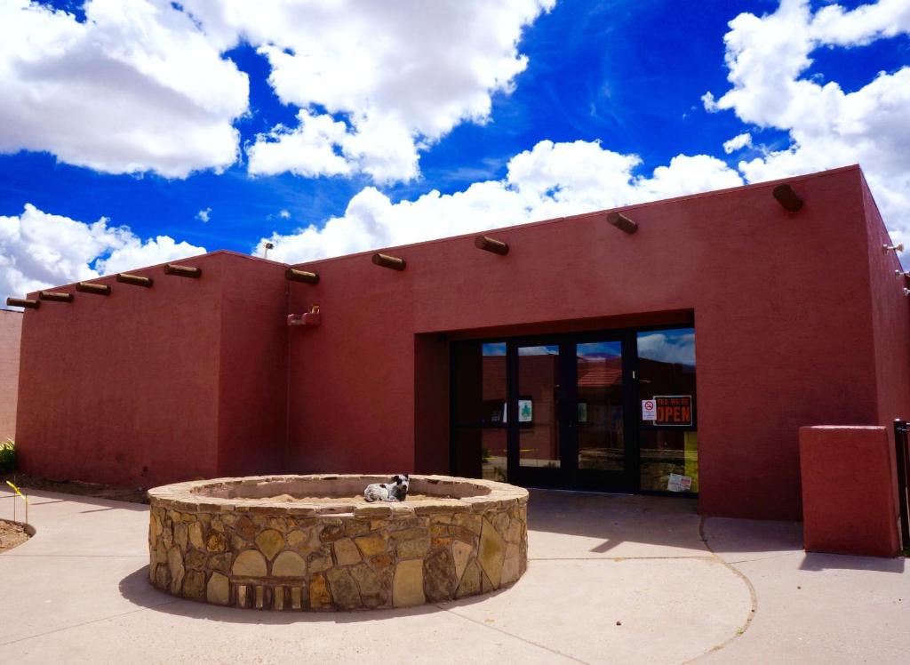 un edificio rojo con una fuente frente a un edificio en Hopi Cultural Center, en Shongopovi