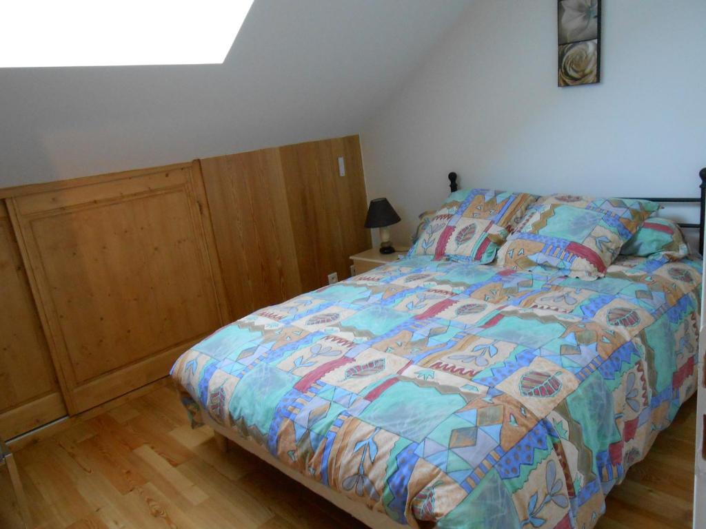 a bedroom with a bed with a colorful comforter at Gite du Cret in Hotonnes