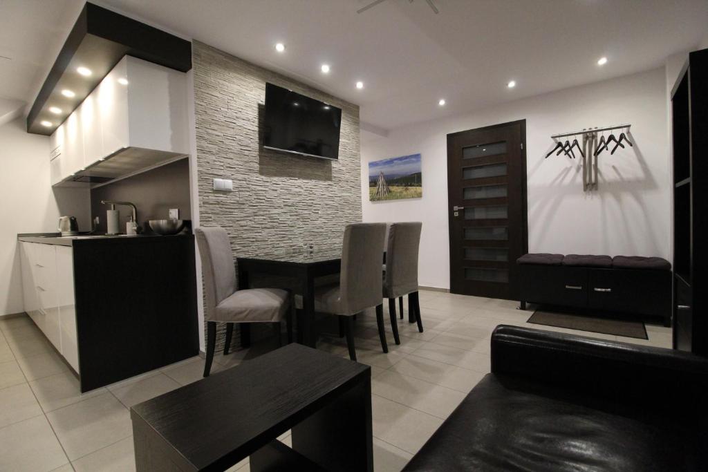cocina y sala de estar con mesa y sillas en Apartament Meander en Szklarska Poręba